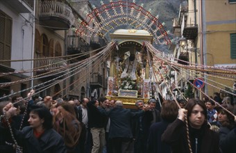 ITALY, Sicily, Easter procession with statue of a saint being carried through the street