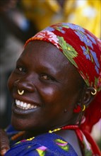 MALI, Body Decoration, Smiling African woman wearing floral headscarf and small gold nose ring