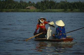VIETNAM, South, Saigon, Woman paddling a small boat in the traditional way with her feet on the