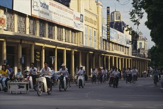 VIETNAM, North, Hanoi, Mopeds in a street lined with colonnaded buildings