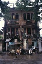 VIETNAM, North, Hanoi, Decayed French colonial style residential buildings with people sheltering