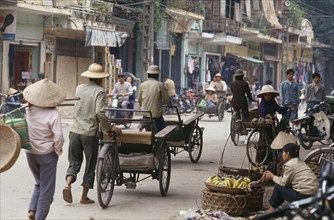 VIETNAM, North, Hanoi, Busy street with bicycles cyclos and street vendors