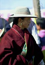 CHINA, Gansu, Xiahe, Lady watching festival wearing a hat