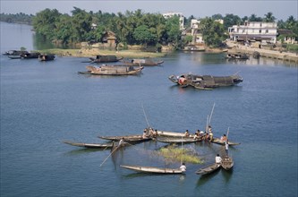 VIETNAM, Hue, Perfume River, Fishermen on boats with a net cast around reeds in the river