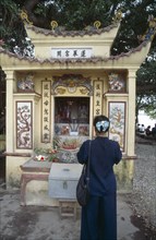 VIETNAM, North, Hanoi, Woman praying at a shrine