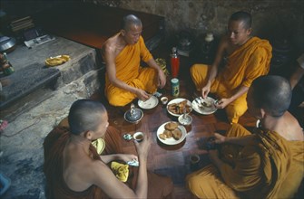 THAILAND, Food and Drink, Buddhist monks eating meal in monastery.