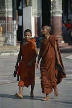 MYANMAR, Yangon, Shwedagon Pagoda.  Two Therevada Buddhist monks.