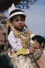 MYANMAR, Children, Very young boy at novice monk initiation ceremony.