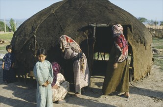 IRAN, Indigenous People, Turkoman women setting up an Alchehh or tent