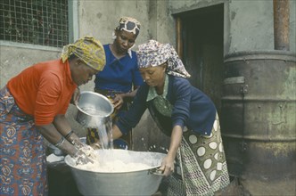 TANZANIA, Arusha, Women preparing dough to make bread.