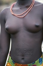 SUDAN, Scarification, Symmetrical pattern of raised scars decorate the abdomen of a young Dinka