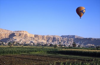 EGYPT, Nile Valley, Thebes, "Valley of the Kings with hot air balloon above agricultural land,
