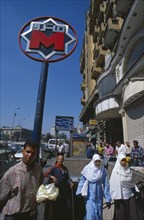 EGYPT, Cairo , Nasser metro station.  Men and women at subway entrance with sign above.
