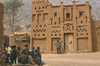 MALI, Architecture, Dogon village Elders house with man standing outside and group of children in