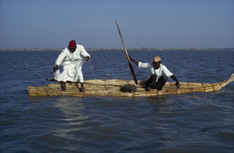 CHAD, Lake Chad, Two Buduma tribesmen fishing in a reed boat on the lake