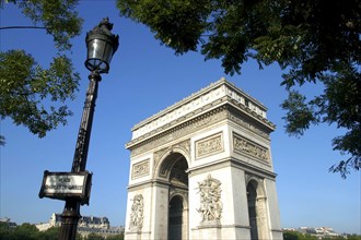 FRANCE, Ile de France, Paris, View of the Arc de Triomphe with lampost and sign in the foreground