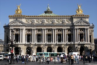 FRANCE, Ile de France, Paris, The Opera Garnier columned facade with golden statues a top and crowd