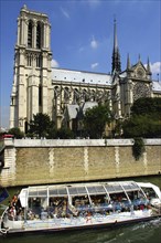 FRANCE, Ile de France, Paris, Glass topped tourist boat passing the Notre Dame Cathedral