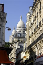 FRANCE, Ile de France, Paris, Sacre Coeur domes seen from a side street