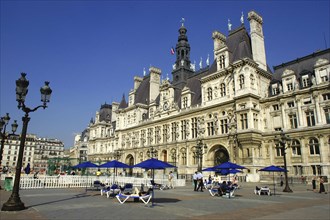 FRANCE, Ile de France, Paris, Hotel de Ville overlooking pedestrianized square with umbrellas and