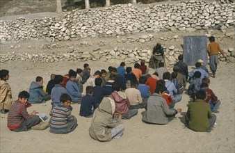 PAKISTAN, North West Frontier, Karimabad, Outdoor classroom for boys only with teacher seated