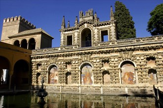 SPAIN, Andalucia, Seville, The Royal Alcazar exterior wall and pond
