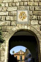 SPAIN, Andalucia, Seville, The Royal Alcazar. Stone archway with the coat of arms above