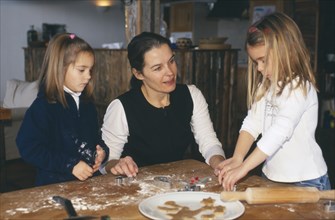 FAMILY RELATIONS, Parents, Mother, Woman making gingerbread cookies with her two young daughters.