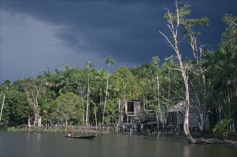 BRAZIL, Amazonas, Amazon Basin, View toward riverside Cabloclo settlement with dark storm clouds