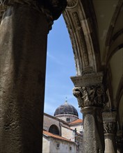 CROATIA, Dalmatia, Dubrovnik, Cathedral dome seen trough archways of Rectors Palace