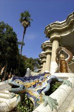 SPAIN, Catalonia, Barcelona, Gaudi dragon covered in brightly coloured tiles on the steps in Parc