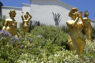 SOUTH AFRICA, Western Cape, Cape Town, Golden statues standing among flowers at a Winery