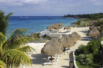 MEXICO, Quintana Roo, Cozumel Island, View over sandy beach with thatched umbrellas