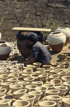 MYANMAR, Kyaukmyaung, Woman worker in pot making centre.