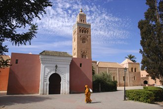 MOROCCO, Marrakech, Koutoubia Mosque with entrance gate and tower and passing woman