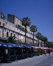 CROATIA, Split, The restored walls of the Diocletian Palace with umbrella coverred cafe tables on