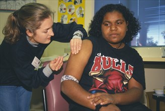 AUSTRALIA, Western Australia, Kalgoorlie, Aboriginal girl receiving Rubella vaccination from female