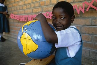MALAWI, Blantyre, Schoolgirl with papier mache globe teaching aid made by PAMET who recycle