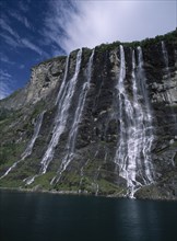 NORWAY, Romsdal, Geirangerfjord, Seven Sisters mountain cliff with cascading waterfall.