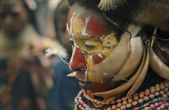 PAPUA NEW GUINEA, Portraits, Men, Tribesman with painted face and pierced nose.
