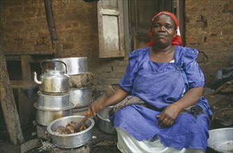UGANDA, Kampala, Woman cooking for large household.