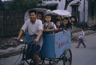CHINA, Transport, Cycle powered baby carriage full of young children.