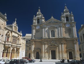 MALTA, Mdina, St Paul’s Square and Mdina Cathedral. View of exterior with cars parked in front.