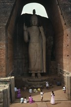 SRI LANKA, Aukuna, Large standing Buddha towering over people below