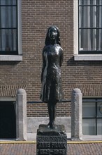 HOLLAND, Noord, Amsterdam, Westermarkt. Statue of Anne Frank the young diary writer during the Nazi