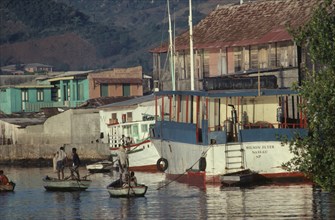 HAITI, Transport, Harbour with moored boats and men in shallow wooden rowing boats.