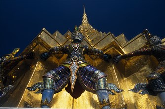 THAILAND, Bangkok, Grand Palace. Demon statue at the base of a spire or prang.