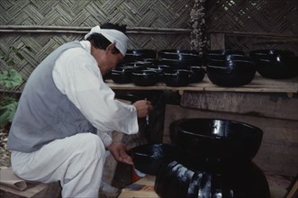 SOUTH KOREA, Crafts, Korean Folk Village.  Man lacquering wooden bowls.