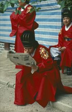 SOUTH KOREA, Seoul, Confucian devotee reading a newspaper during break from rites.
