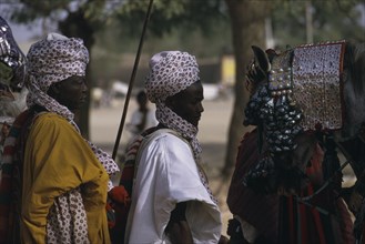 NIGERIA, Katsina, Salah Day.  The Emirs entourage including horse wearing heavily decorated bridle.